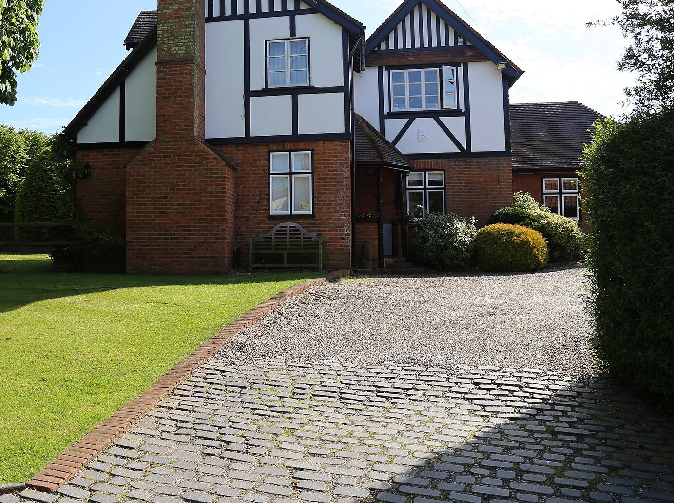 Gravel drive held by a brick edge, with a sett apron